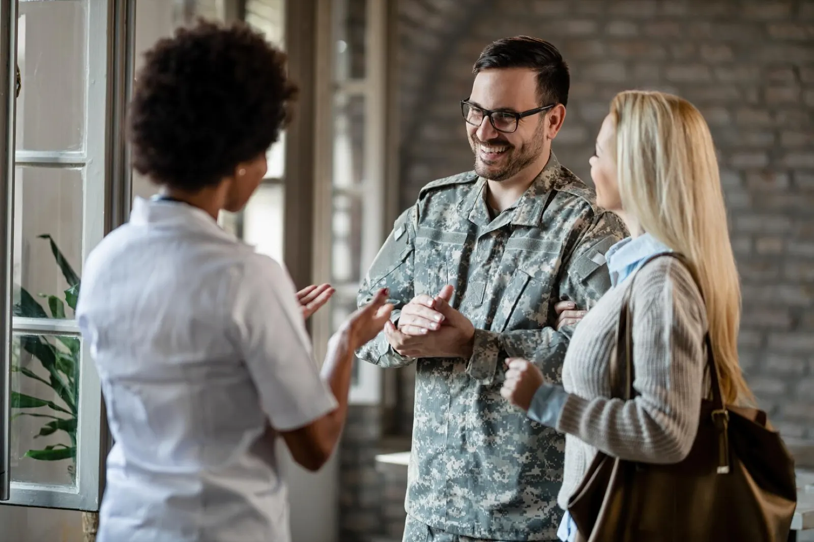 A soldier and his wife speaking with a healthcare worker